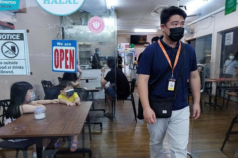 Enforcement officer Aldric Ang making sure safe management measures were followed at an F&B outlet in Jalan Leban yesterday.