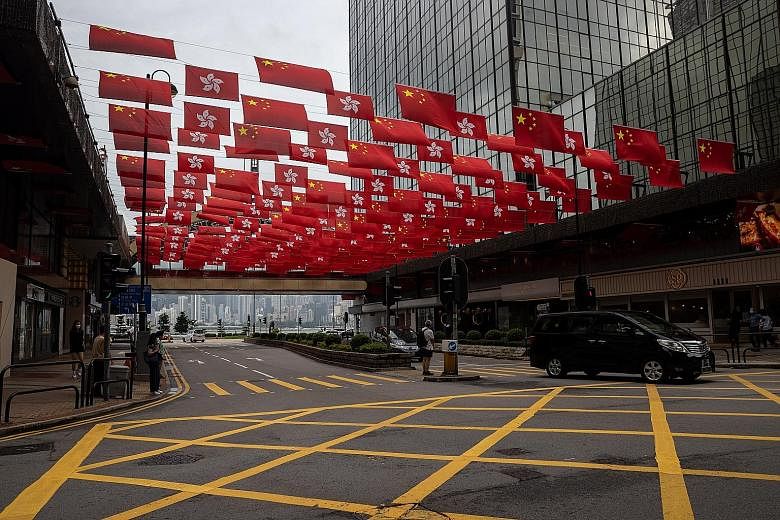 Flags of the People's Republic of China and the Hong Kong Special Administrative Region on display along a street in Hong Kong yesterday. China, Hong Kong and Macau will celebrate the 100th anniversary of the founding of the Chinese Communist Party o