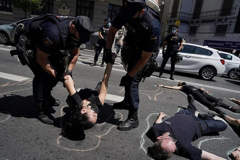 Madrid police officers removing Extinction Rebellion activists earlier this month as they staged a performance calling for the crime of ecocide to be recognised in criminal law in Spain. PHOTO: REUTERS