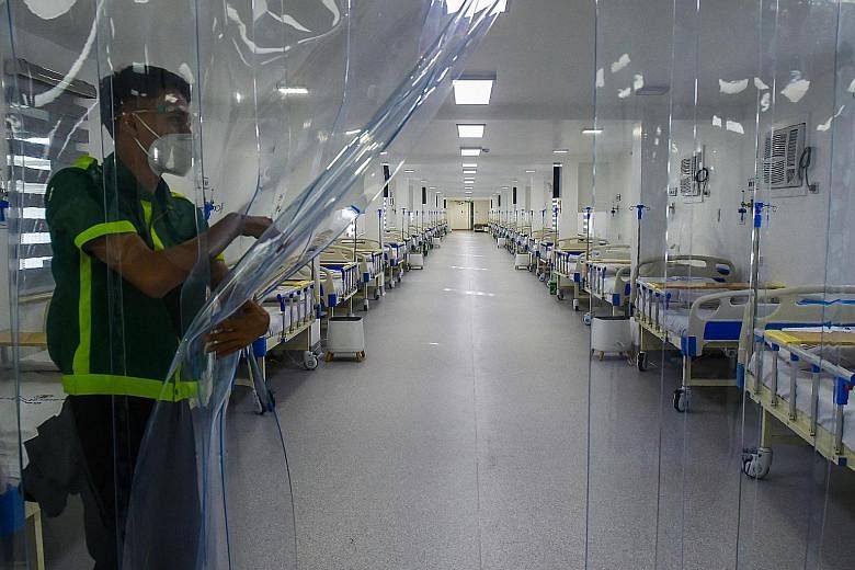 A worker inside an empty field hospital for Covid-19 patients at a park in Manila. Metro Manila has seen Covid-19 cases fall to around 500 a day after recording as many as 8,000 cases daily during a surge that began in December and peaked in April. P