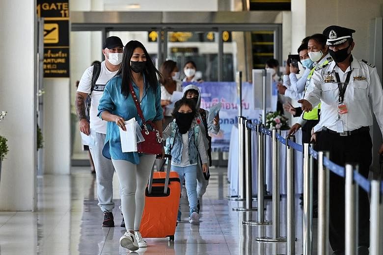 Passengers from a flight from Abu Dhabi arriving at Phuket International Airport yesterday, as the island reopens to overseas tourists. Thailand is allowing foreigners fully vaccinated against Covid-19 to visit the resort island without serving quara