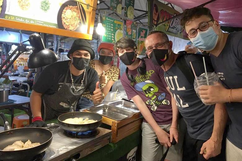 Above: First-time visitor to Phuket Jeremy Ansell, 51, (second from right) flanked by his sons Jake, 17, (far right) and Sam, 14, at a night market in Phuket last Friday. Left: Mrs Angela Lucy Smith and her husband Stuart Smith at Wyndham Grand hotel