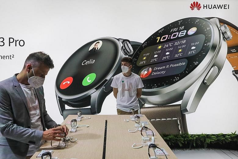 An attendee inspecting Huawei smartwatches at the Chinese technology company's stand on the opening day of the MWC Barcelona in the Spanish city on June 28. Falling prices and new features and shapes for wearables are helping to deliver stronger sale