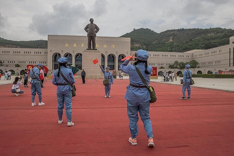Visitors dressed in Red Army uniforms in front of the monument of Chinese leader Mao Zedong at the Revolutionary Memorial Museum in Yan'an, Shaanxi province, China last month. In a modern China grappling with widening social inequality, Mao's words p