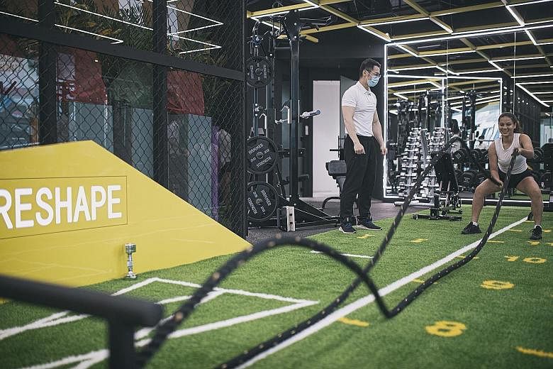 Reshape Space co-founders Dong Haoran (seated), 18, and Zhao Hongwei, 28, are confident that their hybrid gym-cum-tuition business can do well. ST PHOTO: TIMOTHY DAVID Above: Fitness trainer Huang Yingrui, 30, with a client at Reshape Space's gym. Be