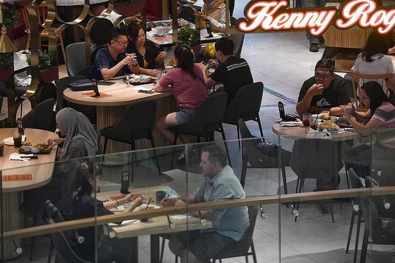Groups of more than two people dining at an eatery in Century Square yesterday. People whom The Straits Times spoke to at different eating places said they were happy about the easing of group limits for dining out. A group of five was among those ha