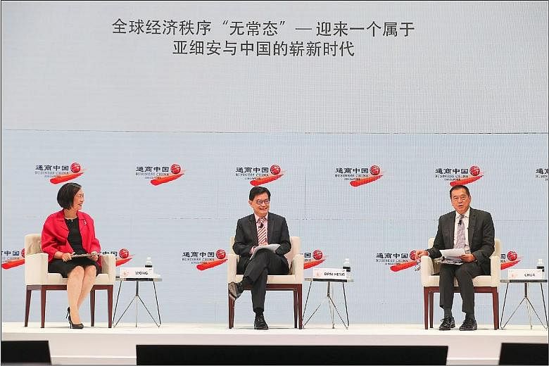 Deputy Prime Minister Heng Swee Keat participating in the plenary discussion yesterday at the FutureChina Global Forum, flanked by panellist Helen Wong, the group chief executive of OCBC Bank; and moderator K.K. Chua, the global vice-chairman of cosm