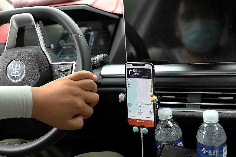 A driver of Chinese ride-hailing service Didi, with a phone showing a navigation map on Didi's app, in Beijing on July 5. A chill has settled over global finance after a fortnight in which China first cracked down on Didi within days of its US tradin