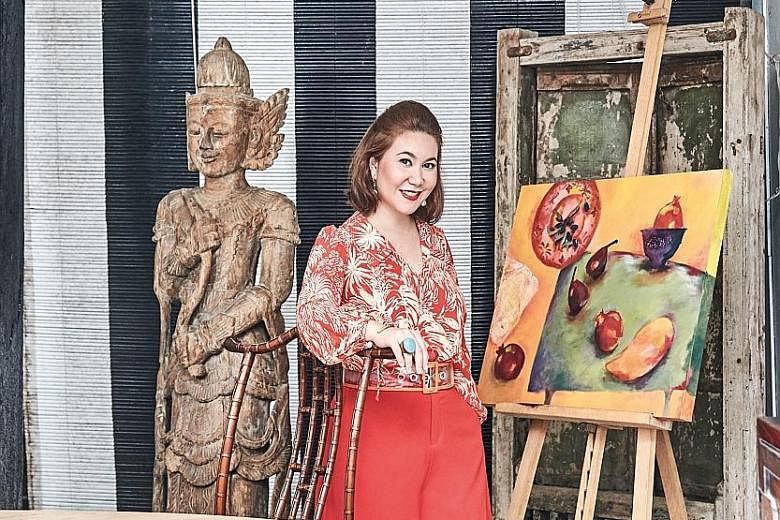 (Above) Ms Malissa Desmazieres with one of her own artworks in the dining corner of her patio, which is decorated with an old Indian window and a Burmese statue. (Left) The indoor living room features a 20th-century Japanese screen, Thai lacquered ca