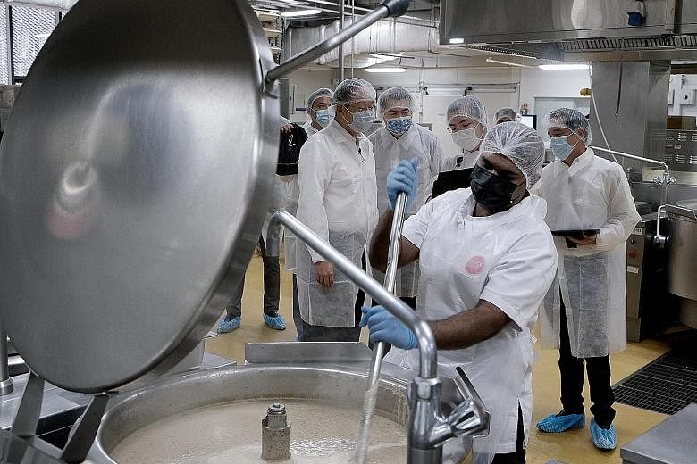 (Background, from left) Manpower Minister Tan See Leng touring the SouperFoods factory with Singapore Business Federation chairman Lim Ming Yan, SouperFoods production manager Cai Ming and managing director Andrew Chan. The firm is one of 90 that hav
