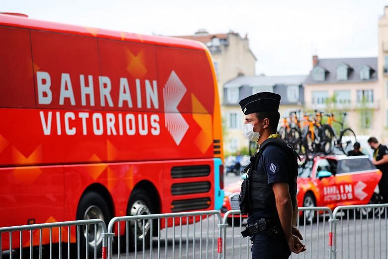 A French policeman stands close to the Bahrain Victorious bus as members of the team prepare for Stage 18 yesterday. The team said they cooperated fully with the authorities.