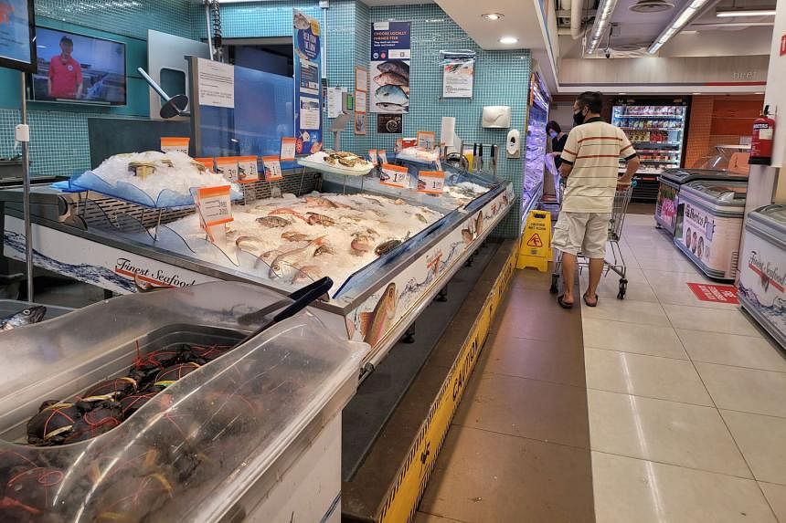 The seafood section of FairPrice Finest in Bedok Mall yesterday. A FairPrice spokesman told The Sunday Times the supermarket chain was working with suppliers to explore alternatives and ramp up fish supplies. The crowd at Tekka Market yesterday. The 