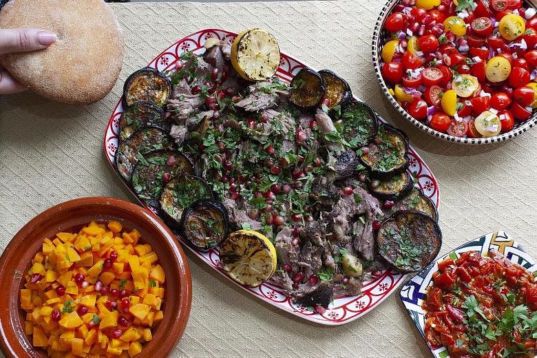 For this year's Eid al-Adha, Ms Nadia Hamila plans to serve dishes including lamb mechoui (centre) with grilled eggplant and Moroccan salads like (clockwise from top right) tomato salad, roasted red pepper salad and carrot salad, and bread.