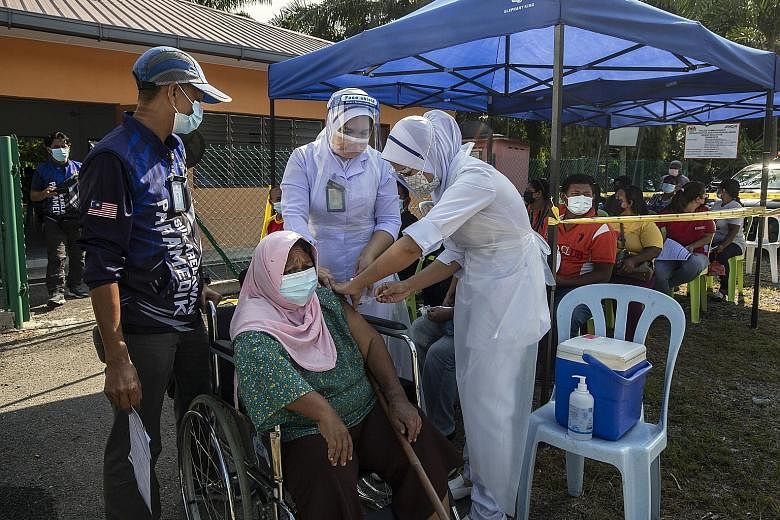 A woman receiving her Covid-19 vaccine jab as part of a vaccination outreach programme in Dengkil town, outside Kuala Lumpur, yesterday. Malaysia has administered over 14 million vaccine doses so far, with nearly 20 per cent of adults fully immunised