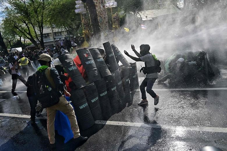 Protesters confronting riot police in Bangkok during a march from the Democracy Monument towards Government House, where Prime Minister Prayut Chan-o-cha works, yesterday.