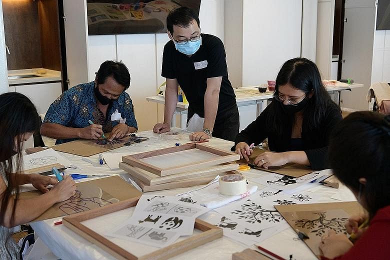 Members of the Myanmar diaspora printing designs on tote bags as part of a National Gallery Singapore tour on Sunday. The tour, which is part of the gallery's Art For Us programme, brought 12 members of the diaspora to view artworks by Myanmar artist