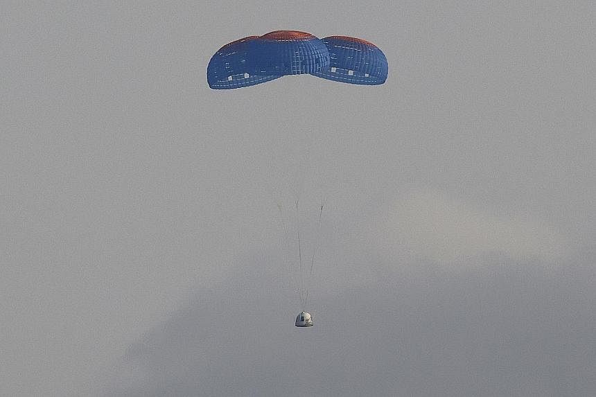 Left: The capsule carrying the crew returning to Earth via parachutes. Below: Mr Bezos (wearing hat) being welcomed on his return while pioneering female aviator Wally Funk emerges from the capsule. Billionaire Jeff Bezos and three crew members aboar