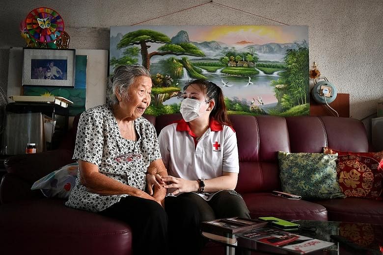 Marine engineer Maggie Chan - a volunteer with the Singapore Red Cross befriending and wellness programme, ElderAid - visits 88-year-old Madam Chen Chin Chee monthly, bringing her food, hand sanitiser and masks. ST PHOTO: LIM YAOHUI