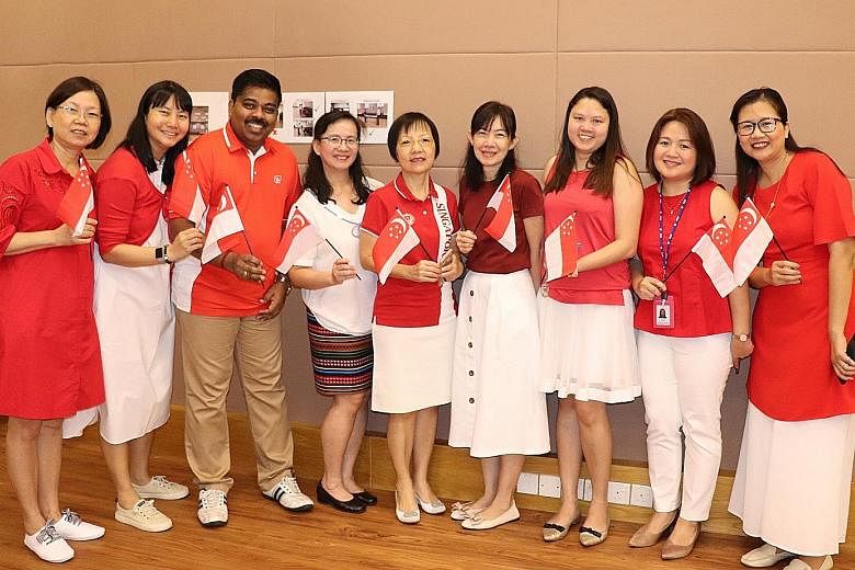 Ms Tan Lee Jee (centre), assistant chief executive officer of the PAP Community Foundation, with the foundation's staff at its National Day Observance Ceremony in 2019.