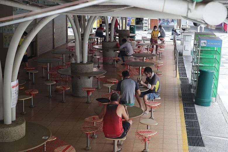 People eating at the 630 Bedok Reservoir Road Market and Food Centre yesterday. Visitors to hawker centres and wet markets will have to check in with their TraceTogether app or token as part of stricter Covid-19 measures. ST PHOTO: TIMOTHY DAVID
