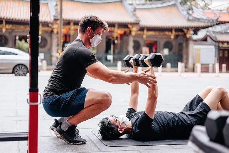 A fitness coach from Level Gym conducting a one-to-one training session. From tomorrow, mask-on activities can be conducted in groups of no more than two people, in classes of up to 30. PHOTO: LEVEL SINGAPORE