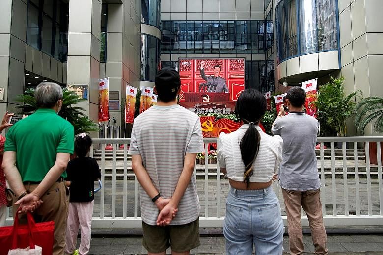 People in Shanghai watching a giant screen airing President Xi Jinping's speech at an event marking the 100th founding anniversary of the Communist Party of China on July 1. In his 70-minute speech, he said remaining loyal to the party and faithful t