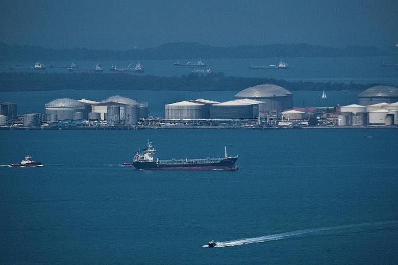 Ships in the waters of the Singapore Strait near Pulau Sebarok, with its oil storage tanks, in April. Singapore is the dominant marine fuel supplier in Asia, but China is catching up.