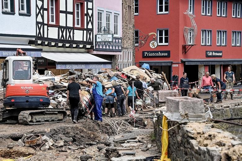 Debris being cleared on Tuesday after heavy flooding of the river Erft last week caused severe destruction in the village of Bad Muenstereifel, Germany.