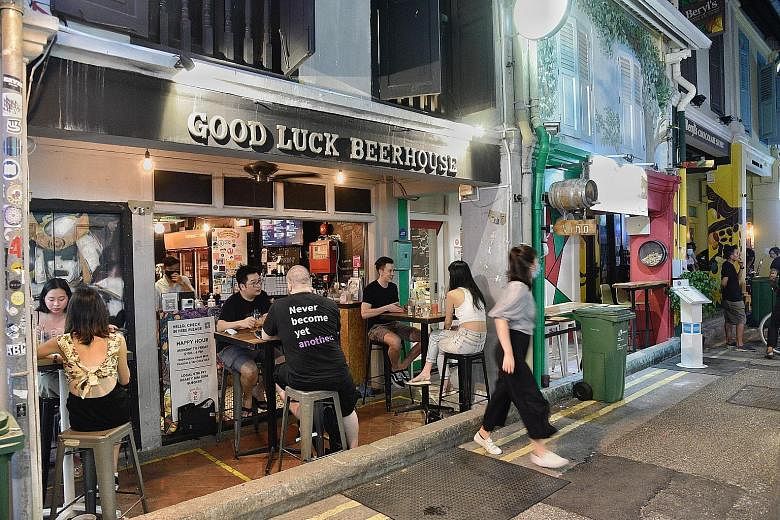 Diners outside Good Luck Beerhouse at Haji Lane yesterday before new restrictions kick in today. The bar offered a whole-day Happy Hour yesterday with a 15 to 20 per cent discount for its draft beers and tap cocktails.