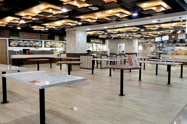An empty Koufu Foodcourt at Orchard Cineleisure around 5.30pm yesterday, which marked the start of restrictions on dining in. Patrons can only take away purchased food. A stall selling pork was among the few stalls open at Geylang Bahru Market and Fo