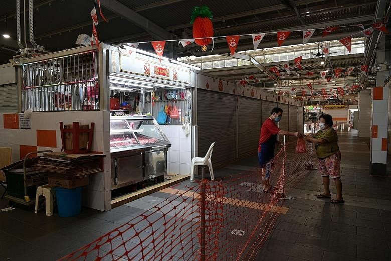An empty Koufu Foodcourt at Orchard Cineleisure around 5.30pm yesterday, which marked the start of restrictions on dining in. Patrons can only take away purchased food. A stall selling pork was among the few stalls open at Geylang Bahru Market and Fo