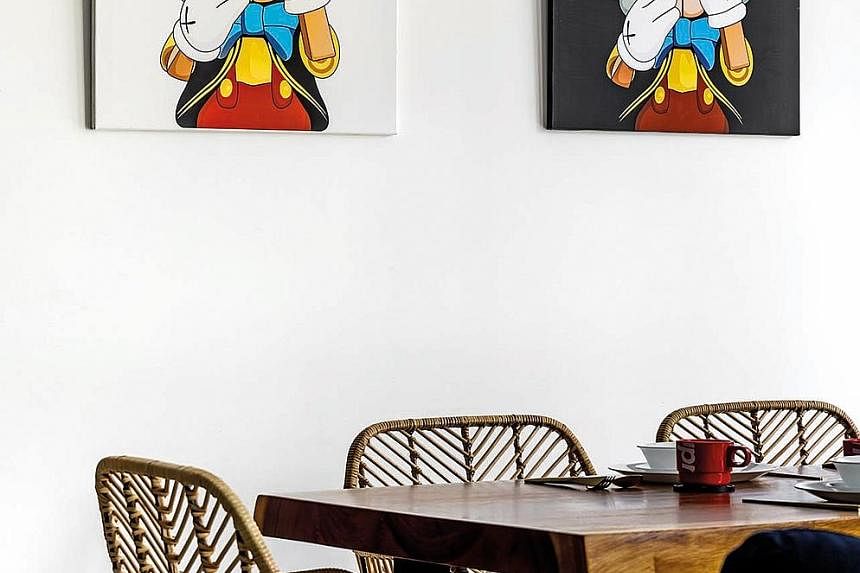 (Above) The living, dining, and dry kitchen zones are distinct yet linked for easy movement. (Left) A Mona Lisa painting and shelves of figurines mounted side by side in one of the bedrooms. (Far left) Kaws-inspired artwork hanging in the dining area