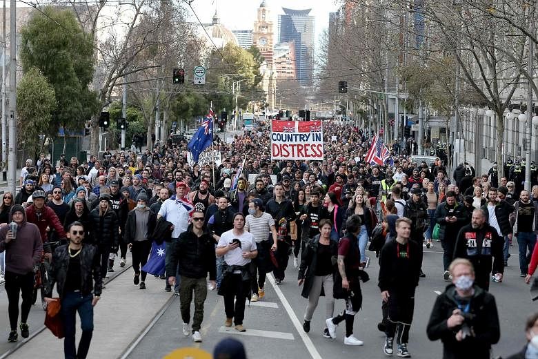Protesters taking part in a rally in Melbourne yesterday. The largely maskless protesters were flouting rules on non-essential travel and public gatherings, a day after the authorities suggested the restrictions could remain in place until October. P