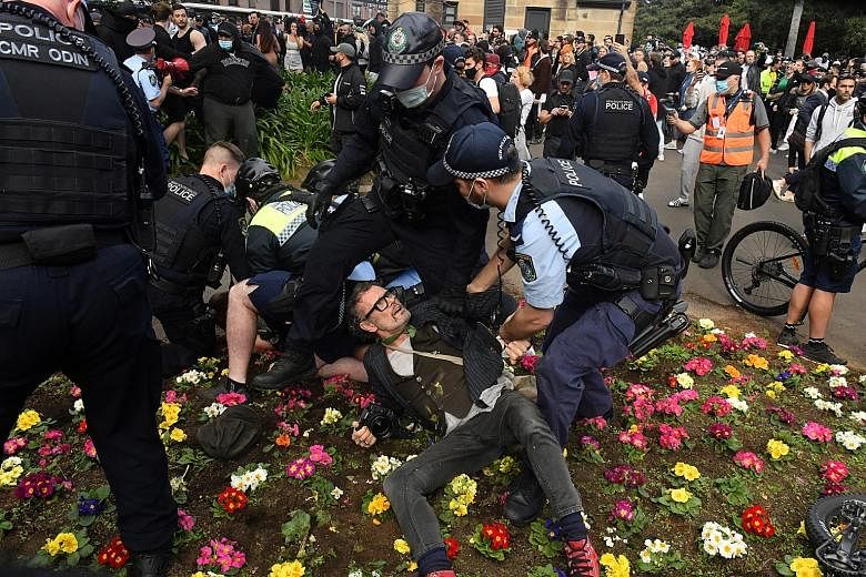 Police officers detaining protesters during an anti-lockdown rally in Sydney, capital of New South Wales, last Saturday. Numbers of coronavirus cases in the Australian state have stayed stubbornly high even after four weeks of lockdown in Sydney, now