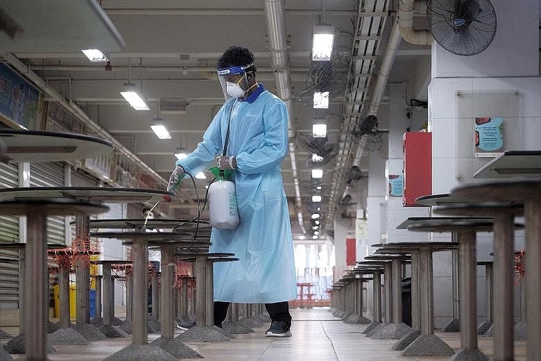 Hong Lim Market and Food Centre being disinfected on July 18. The cluster at Jurong Fishery Port was first discovered on July 16, with multiple infections detected at the port, as well as at Hong Lim Market and Food Centre.