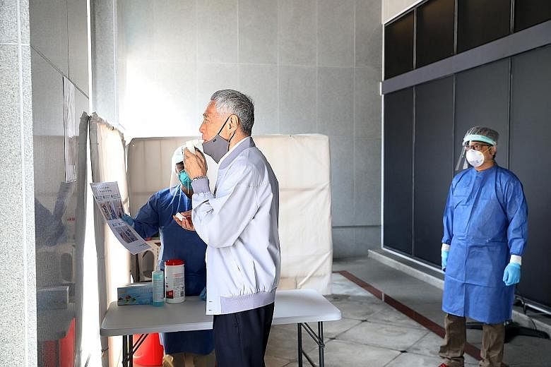 Prime Minister Lee Hsien Loong taking a Covid-19 breathalyser test before attending Parliament yesterday. The TracieX breathalyser test was developed locally by Silver Factory Technology, a start-up from Nanyang Technological University. PM Lee descr