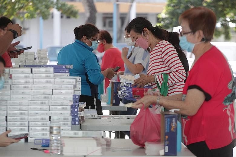 Residents collecting their free antigen rapid test self-test kits in Geylang Bahru on Monday. All households will progressively receive self-test kits.