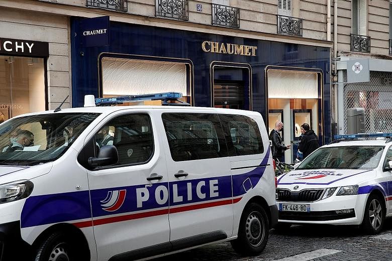 Police vehicles outside the Chaumet jewellery store in central Paris where an armed man was reported to have arrived on a scooter and brandished a weapon inside the store before fleeing on the two-wheeler on Tuesday.