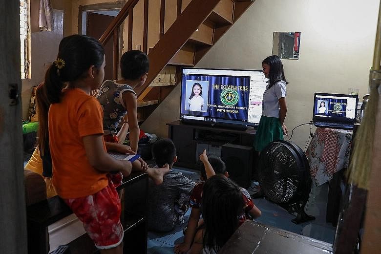 Relatives of Annika Torres (right) watching as her name is displayed during her online graduation in Santo Tomas in the Philippine province of Pampanga earlier this month.
