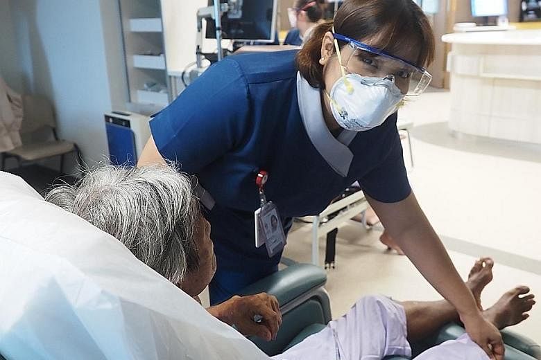 Ms Prema Harrison attending to a patient. She also worked during the Sars epidemic in 2003 and the H1N1 crisis in 2009.