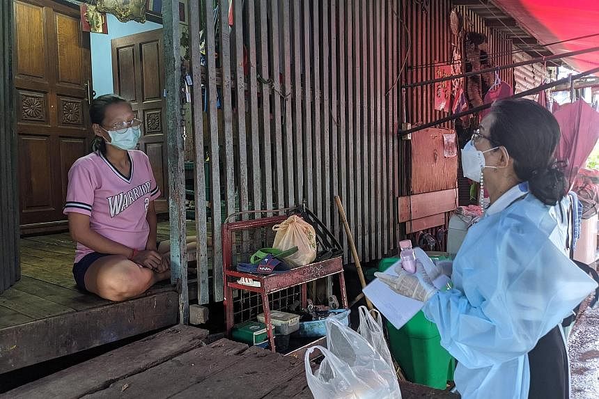 Ms Prateep Ungsongtham Hata (right), 69, who founded the Duang Prateep Foundation, reaching out to Ms Chuanpit Sopa, 27, who is five months pregnant, and her family in the Khlong Toey slum community in Bangkok. Ms Chuanpit, her husband and their daug