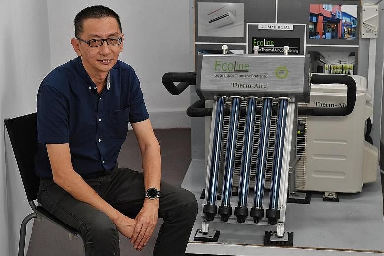 Mr Colin Chia, co-founder of Ecoline Solar, with the solar thermal air-conditioning system manufactured by his firm. ST PHOTO: CHONG JUN LIANG