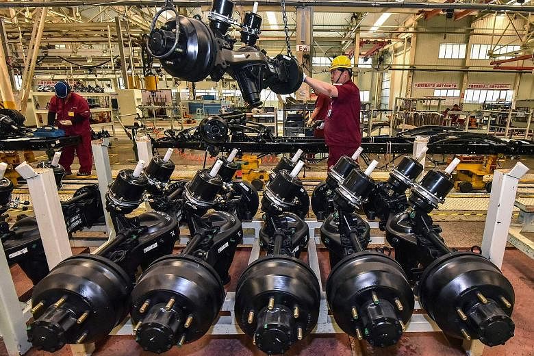 Left: Workers producing truck parts at a factory in Qingzhou, in China's Shandong province, in June. China's Caixin/Markit Manufacturing Purchasing Managers' Index fell to 50.3 last month from 51.3 in June - the lowest level in 15 months. Right: A pl