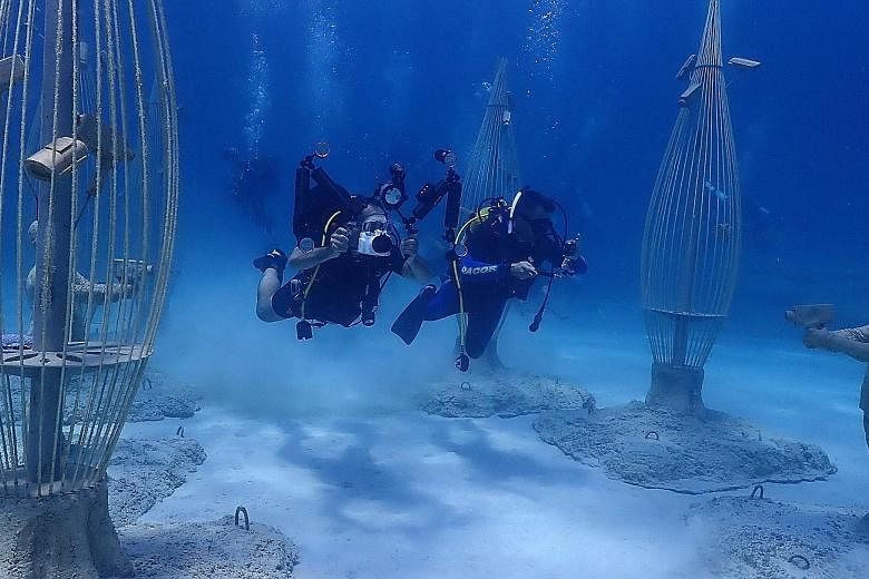 Divers enjoying a view of sculptures at the inauguration of the Ayia Napa Underwater Sculpture Museum in Ayia Napa, Cyprus, on Sunday. At the museum, visitors will be able to take a tour in an underwater forest, the first of its kind. The project was