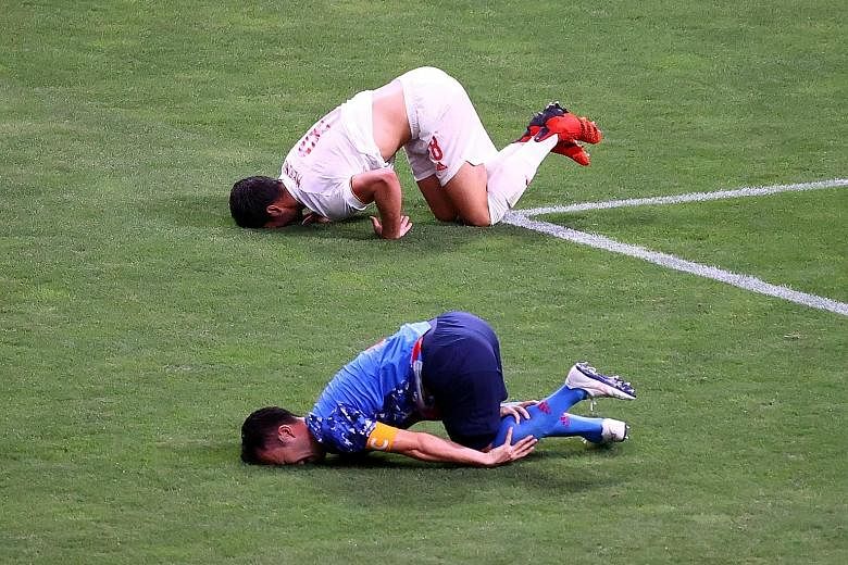 Mikel Merino of Spain (in white) and Maya Yoshida on the ground after a tackle by the Japan captain and defender. The penalty that was awarded was overruled by the VAR.
