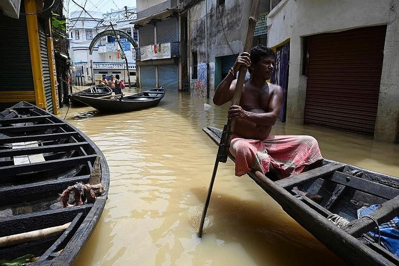 Boats floating along a road submerged by floodwaters following heavy monsoon rain in Ghatal, Paschim Medinipur district, about 100km from Kolkata, on Monday.