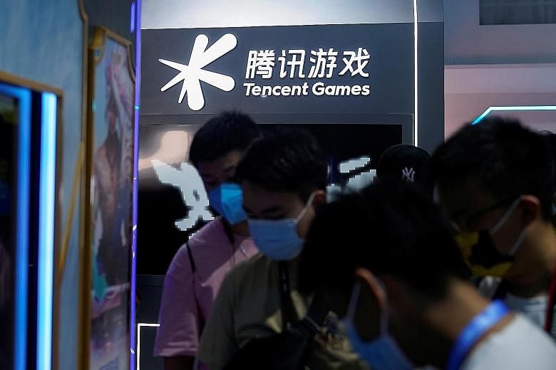 Visitors at the Tencent Games booth during the China Digital Entertainment Expo and Conference in Shanghai on July 30. The company on Tuesday said it will introduce more measures to reduce minors' time and money spent on games. It also called for an 