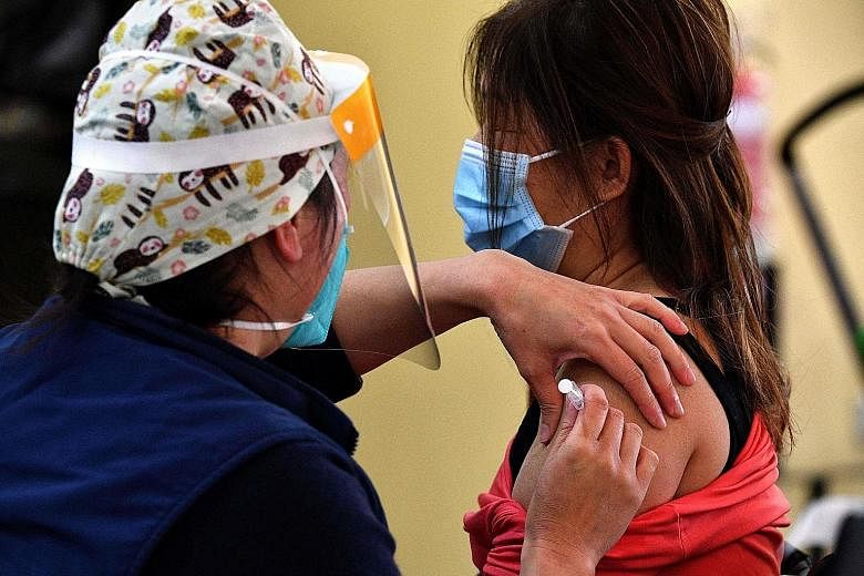 A woman receiving a dose of the AstraZeneca vaccine at a walk-in Covid-19 clinic in the Smithfield suburb of Sydney on Wednesday. Only 20 per cent of Australia's population over 16 years old is fully vaccinated against the coronavirus. PHOTO: AGENCE 