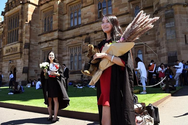A 2017 photo showing a student from China posing for pictures upon graduating with a master's degree from the University of Sydney in Australia. The country's strict travel curbs have left the international education sector frozen, leading to a loss 