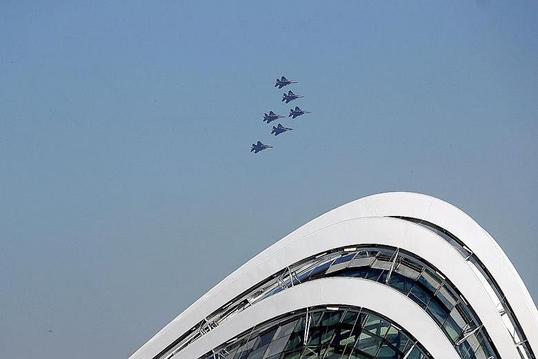 Chinook helicopters, each escorted by a pair of Apache helicopters, flying by in the south of Singapore yesterday. They were carrying the state flag for heartland fly-pasts covering the eastern and western parts of the island. The F-15SG jets soaring